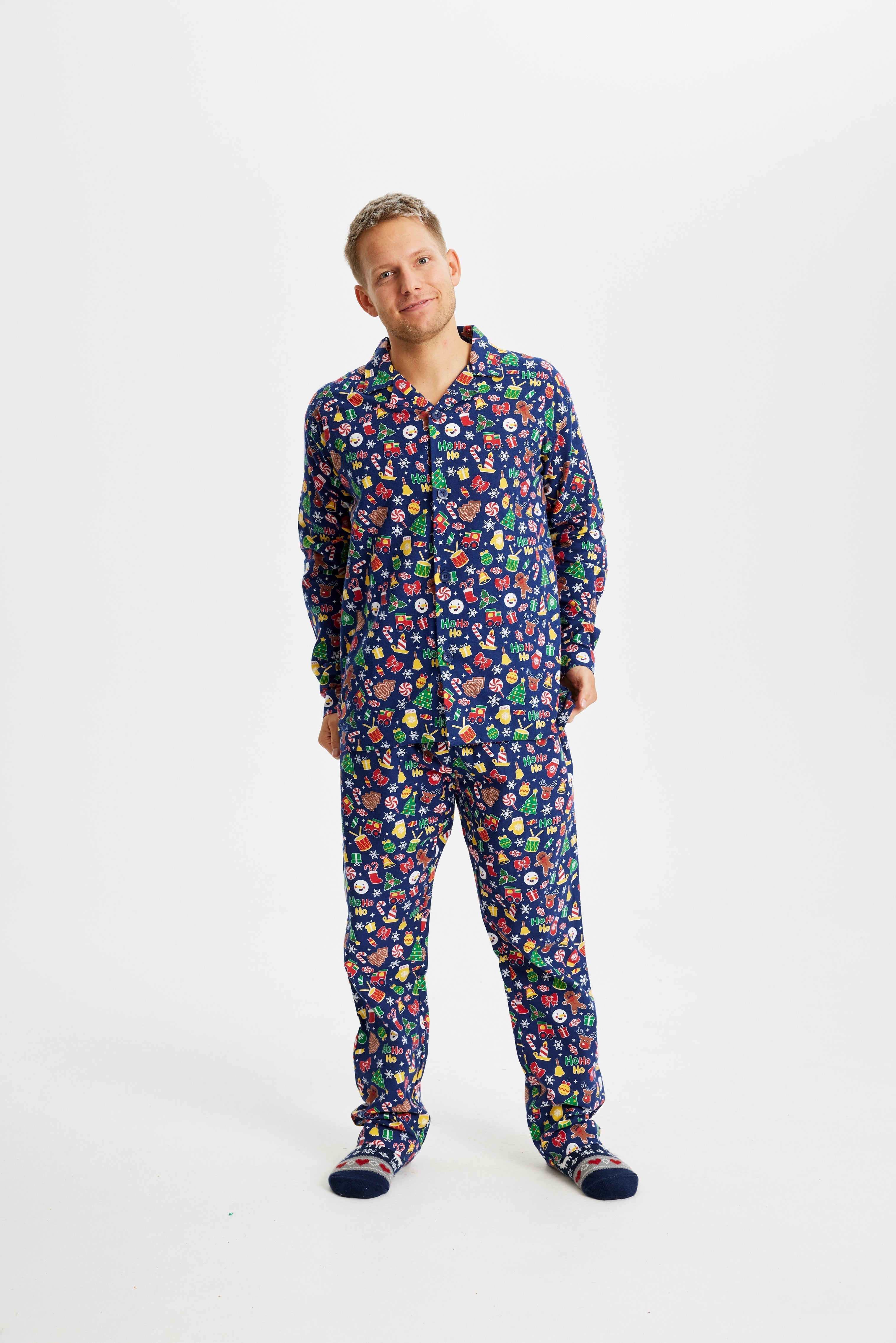 Een poserende man in een blauwe kerstpyjama.